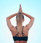 Rearview beautiful woman practising yoga exercise on the beach. Young female athlete stretching while working out outside. Finding inner peace and balance. Focused on health and a fitness lifestyle