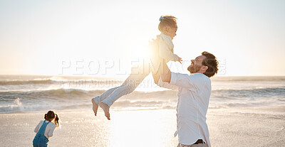 Little being lifted by her father. Cheerful father lifting his daughter. Carefree father on holiday with his children. Sisters playing with their father on vacation. Parent bonding with his children