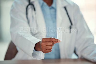 hands of doctor holding a covid test. Closeup of african american doctor holding negative corona virus test. Medical professional sitting at their desk with a corona test.