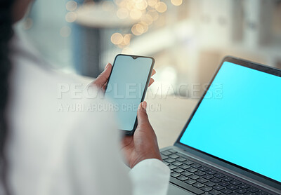 Doctor using multiple digital devices at work. Medical professional sending a text on a smartphone. Healthcare worker browsing an online app on her cellphone. Hands of doctor using a mobile phone
