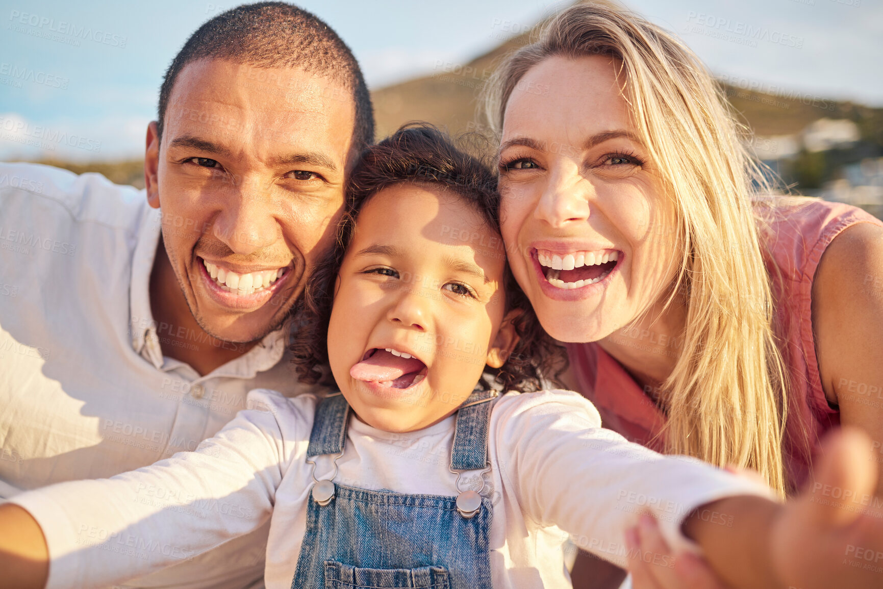 Buy stock photo Face selfie, comic and funny happy family on a trip, vacation or holiday outdoors. Portrait, love and caring mother, father and child together at beach taking pictures spending free time bonding.
