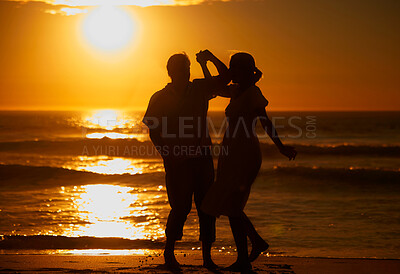 Buy stock photo Silhouette affectionate senior couple sharing an intimate moment on the beach. Backlit happy husband and wife enjoying a summer day by the sea. They love spending time together on the coast at sunset