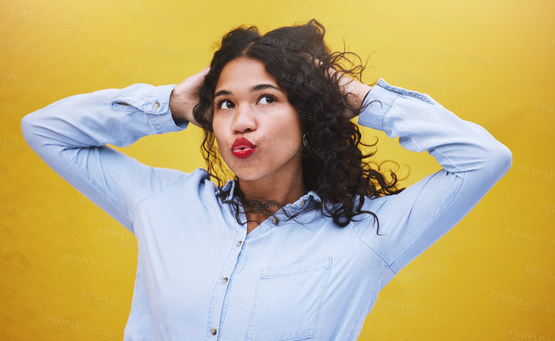 Buy stock photo Freedom, beauty and youth, a black woman blowing a kiss or pouting with yellow background. Portrait of happy girl with hands in curly hair, kissing air. Fun, crazy and excited expression on female.