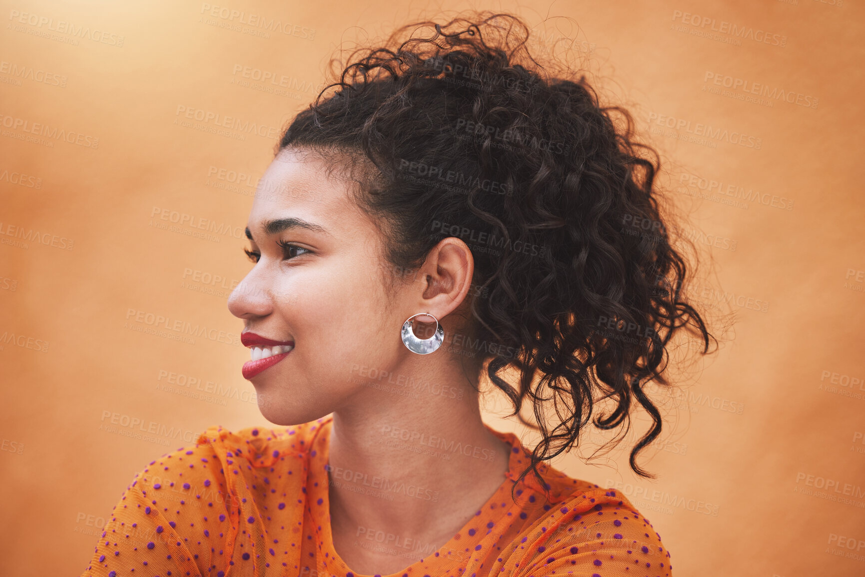 Buy stock photo Face, beauty and hair with a woman in studio against an orange background while posing with a smile from the side. Fashion, happy and idea with a young female standing on a bright color wall indoor