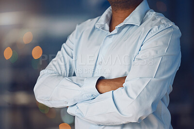 Buy stock photo Closeup young african man standing with his arms crossed while working late at night in his office. African american business man looking confident and powerful while putting in overtime after hours