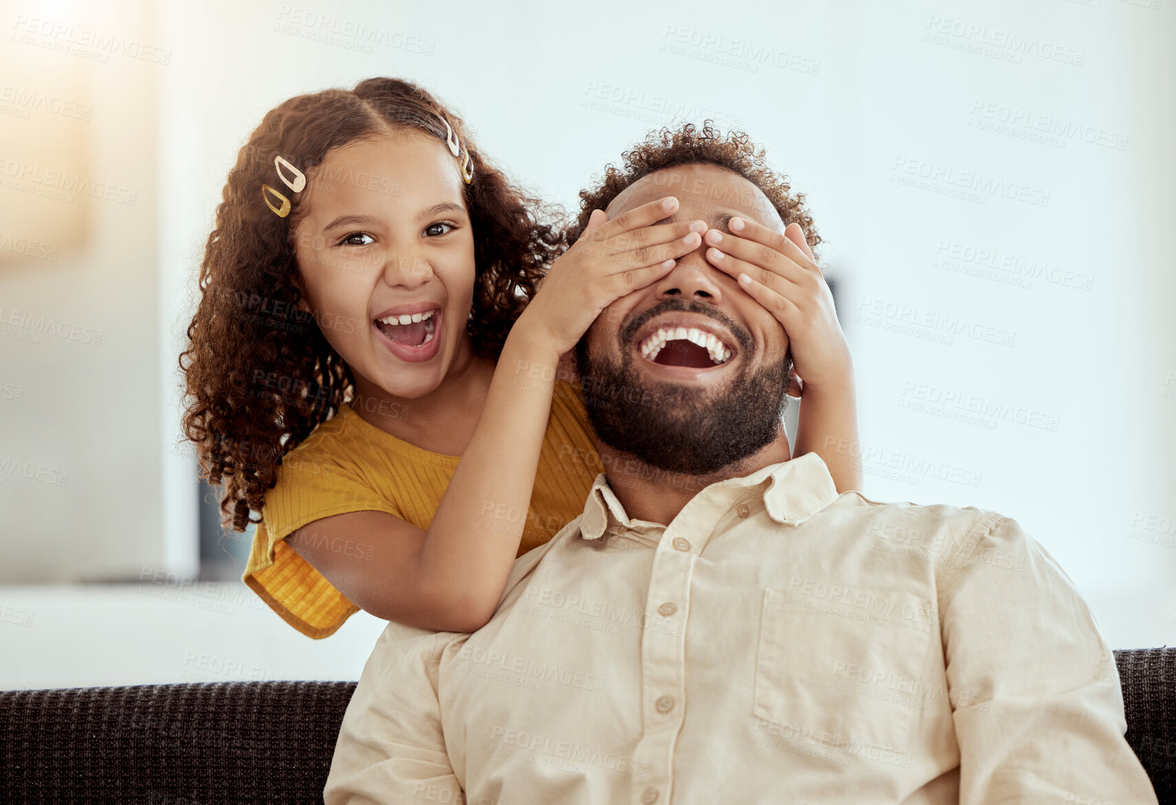 Buy stock photo Mixed race single father and daughter feeling playful in home living room. Smiling hispanic girl bonding and covering single parent’s eyes in lounge. Happy man and child playing hide and seek together
