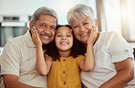 Portrait of mixed race grandparents enjoying weekend with granddaughter in home living room. Smiling hispanic girl bonding with grandmother and grandfather. Happy seniors and child sitting together