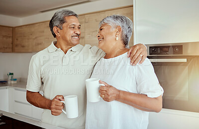 Buy stock photo Mixed race senior couple enjoying coffee in the morning at home. Smiling elderly husband and wife standing together and drinking tea in kitchen. Happy retired ethnic man and woman hugging and bonding