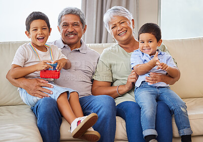 Buy stock photo Portrait of smiling grandparents while holding their grandsons on a sofa in the lounge. Senior hispanic man and woman spending time with their grandkids in the lounge at home