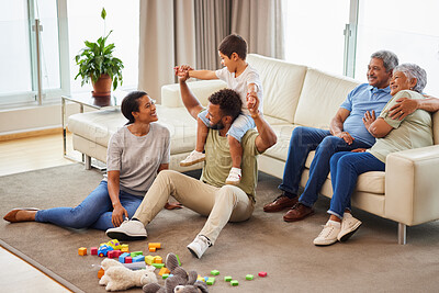 Buy stock photo A mixed race family bonding together while parents playing with the kids while the grandparents relax on the couch at home