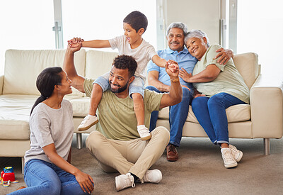 Buy stock photo A mixed race family bonding together while parents playing with the kids while the grandparents relax on the couch at home