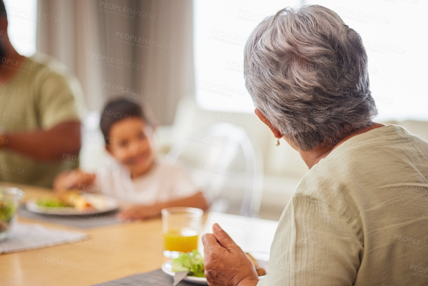 Buy stock photo Mature woman, back and lunch with family, grandchild and eating with bonding, talk and connection. People, grandmother and child together for food, brunch and meal at reunion for nutrition in house