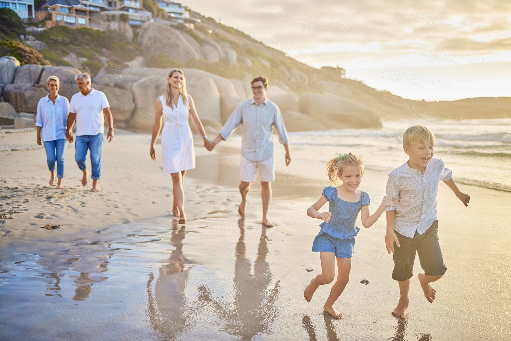 Buy stock photo Family, generations and kids with running, beach and sunset with men, women and happiness with love. Parents, grandparents and children by ocean, holding hands or bond on summer vacation with smile