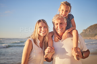 Buy stock photo Portrait of a little caucasian girl being carried by her grandpa while her mother walks on the beach during sunset.  Family fun in the summer sun