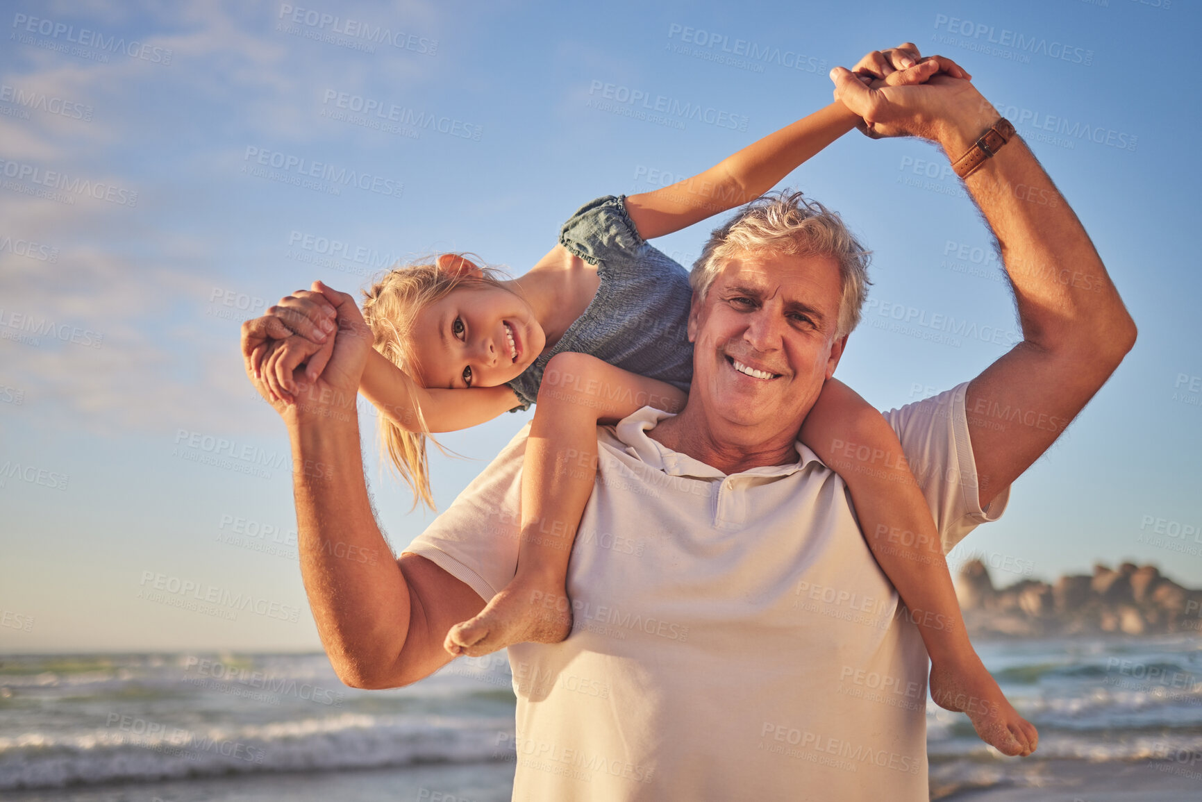 Buy stock photo Portrait of Grandfather carrying his granddaughter on his shoulders while walking along the beach. Adorable little girl sitting on grandpa's shoulders while holding hands and smiling