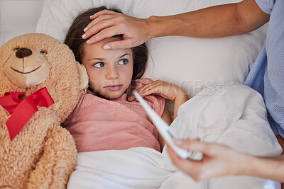 Buy stock photo Sick little girl in bed with her teddybear while her mother uses a thermometer to check her temperature. Young concerned single parent sitting with sick child while and feeling her forehead . Small child feeling ill while her mother checks fever