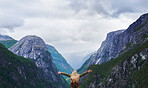 Travel adventure woman celebrates arms raised  at view of majestic glacial valley on exploration discover beautiful earth