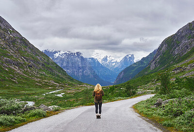Buy stock photo Adventure backpacking woman travels on road in epic majestic mountain snow landscape