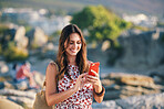 Beautiful woman using smartphone texting on beach at sunset 