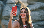 Beautiful woman taking photo using smartphone on beach at sunset 