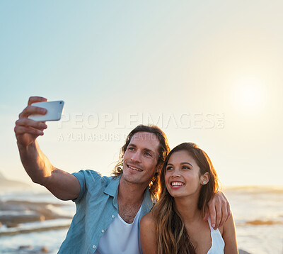 Buy stock photo happy couple taking photo using smartphone on beach sharing romantic vacation together