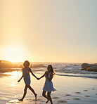 woman friends running on beach at sunset holding hands having fun summer vacation enjoying freedom