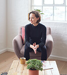 Beautiful woman smiling looking out window feeling positive sitting on sofa at home