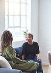 two woman friends talking having conversation sitting on sofa at home