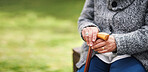 Old woman hands holding walking stick sitting on bench in park retirement lifestyle concept