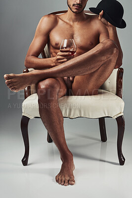 Buy stock photo Studio shot of a handsome and muscular young man having a drink in the nude against a grey background