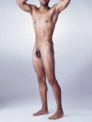 Buy stock photo Studio portrait of a hunky young man posing nude with his hands behind his head against a grey background