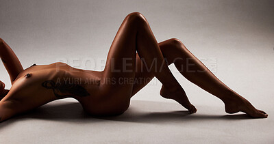 Buy stock photo Studio shot of a beautiful woman posing nude against a black background