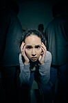One mixed race female suffering mental illness in asylum. Hispanic schizophrenic  woman experiencing a breakdown while being surrounded by people inside.