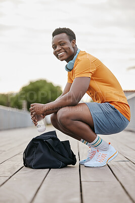 Buy stock photo A happy sports man takes a break from exercising. An African American man looks at the camera while resting on planks. A confident young sporty guy resting.