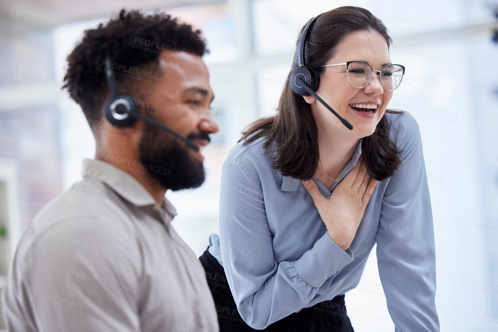 Buy stock photo Cheerful caucasian call centre telemarketing agent training new mixed race assistant on in an office. happy supervisor troub

