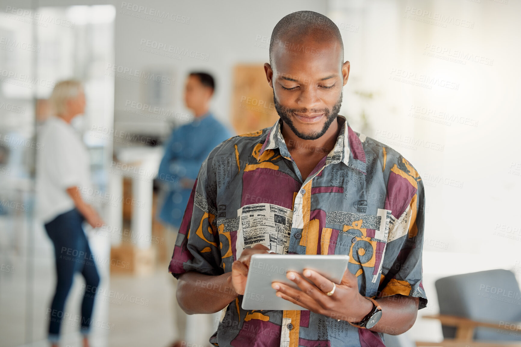 Buy stock photo Happy african american businessman holding and using a digital tablet at work. Male businessperson working on a digital tablet at work. Business professional using social media and browsing online