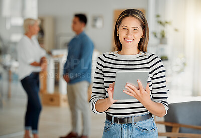 Portrait of a happy mixed race businesswoman holding and using a digital tablet at work. Hispanic female businessperson working on a digital tablet at work. Business professional using social media and browsing online