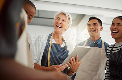 Buy stock photo Group of happy diverse creative designers having a meeting while standing together at work. Cheerful colleagues talking and planning while using a digital tablet in an office. Male and female coworkers discussing a strategy