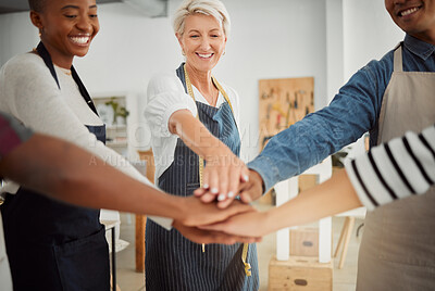 Buy stock photo Group of diverse clothing designers stacking their hands together in a shop at work. Tailors having fun standing with their hands piled for support and motivation during a meeting at a boutique