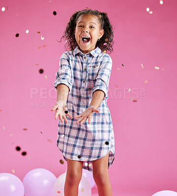 Buy stock photo A pretty little mixed race girl with curly hair celebrating and winning against a pink copyspace background in a studio. African child looking excited at a gender reveal party with confetti
