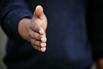 Closeup of an unknown businessman holding his hand out for a handshake in a outside in the city