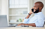 Young african american businessman on a call using a phone while working on a laptop in an office at work alone. One male business professional talking on a cellphone while working