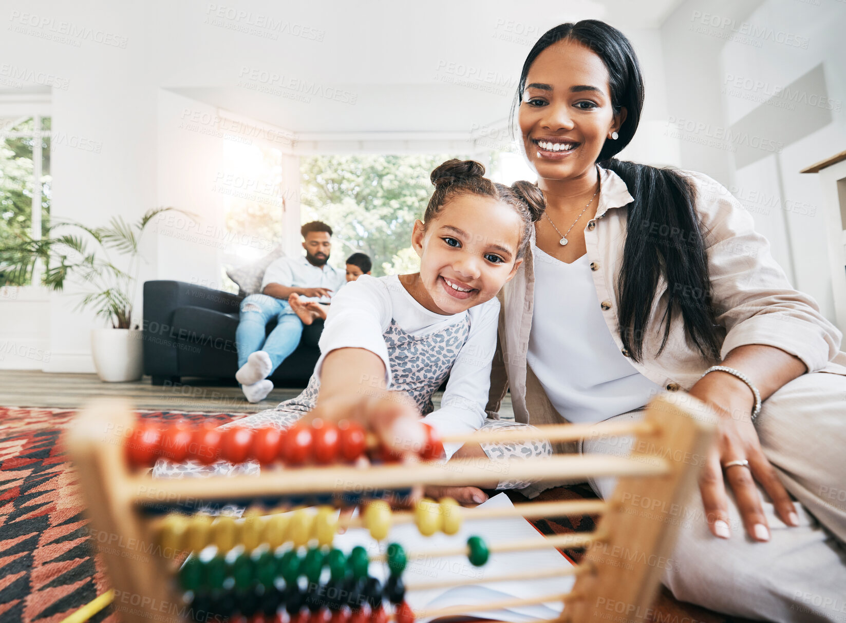 Buy stock photo Hispanic mother sitting on the floor in the lunge at home smiling with her daughter while playing with educational toys. Adorable little girl playing while bonding and spending time with her mom at home while using a abacus to help her kid co