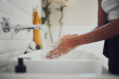 Buy stock photo Close up of female hands using soap and washing hands with clean water under tap. Woman lathering and rinsing to prevent the spread of germs, bacterial infections