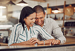 Loving mixed race couple laughing and enjoying time together on first date. Young woman and man on a coffee date in a cafe