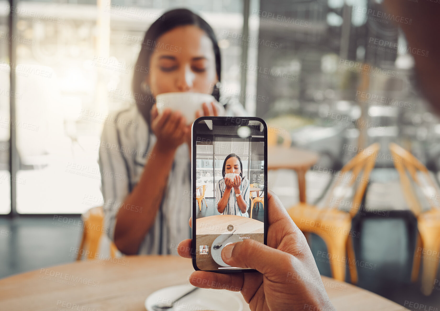 Buy stock photo Close up of device screen while taking picture of beautiful young woman drinking coffee and enjoying date in cafe. Man holding mobile phone and taking photo of girlfriend