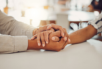 Buy stock photo Close up of young man and woman holding hands at wooden table, from above. Loving couple expressing empathy, understanding and trust in their relationship