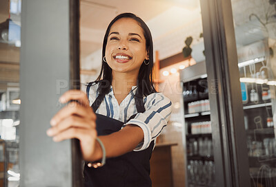 Business owner waiting for customers in her shop entrance. Young businesswoman standing at her coffeeshop door. Happy boss standing in grocery store entrance. Customers known we\'re ready for business