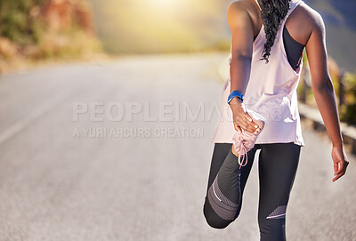 Buy stock photo Close up of african american female athlete stretching before a run outside on a road. Exercise is good for your health and wellbeing. Stretching is important to prevent injury