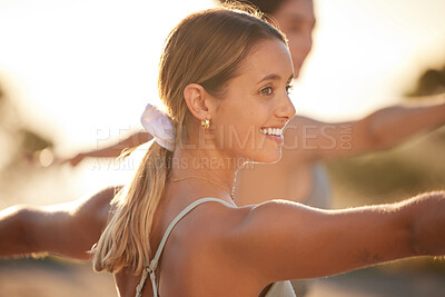 Buy stock photo Two smiling yoga women in warrior pose during outdoor practice in remote nature. Happy active friends bonding and balancing while stretching at sunset. Beautiful, young, active people feeling zen
